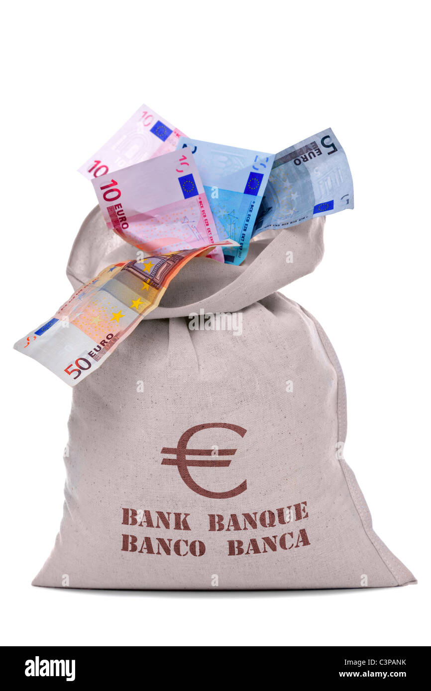 Foto de una bolsa llena de dinero y desbordando los billetes, recortadas sobre un fondo blanco. Foto de stock