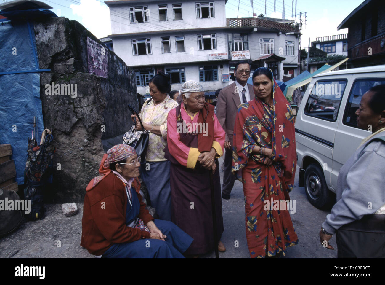 Las mujeres tibetanas locales se congregan en la calle como indios pasan en Gangtok, Sikkim, uno de los estados más pequeños de la India. Foto de stock