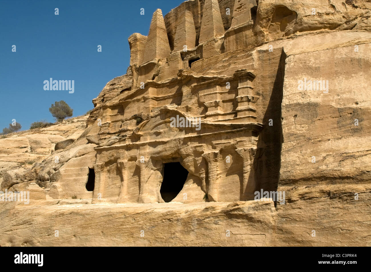 Cuevas talladas en las montañas de arenisca en Petra, Jordania. Foto de stock