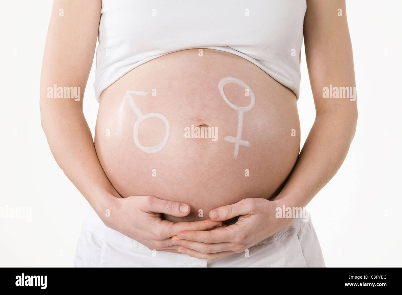 Símbolo masculino y femenino dibujados en el vientre de una mujer embarazada, central Foto de stock