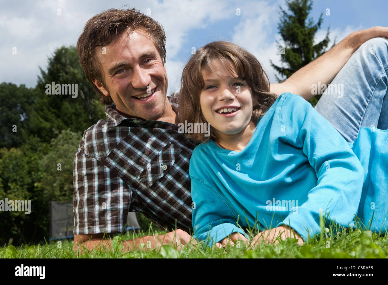 Alemania, Munich, padre e hijo (10-11 años) en el jardín, sonriente, Retrato Foto de stock