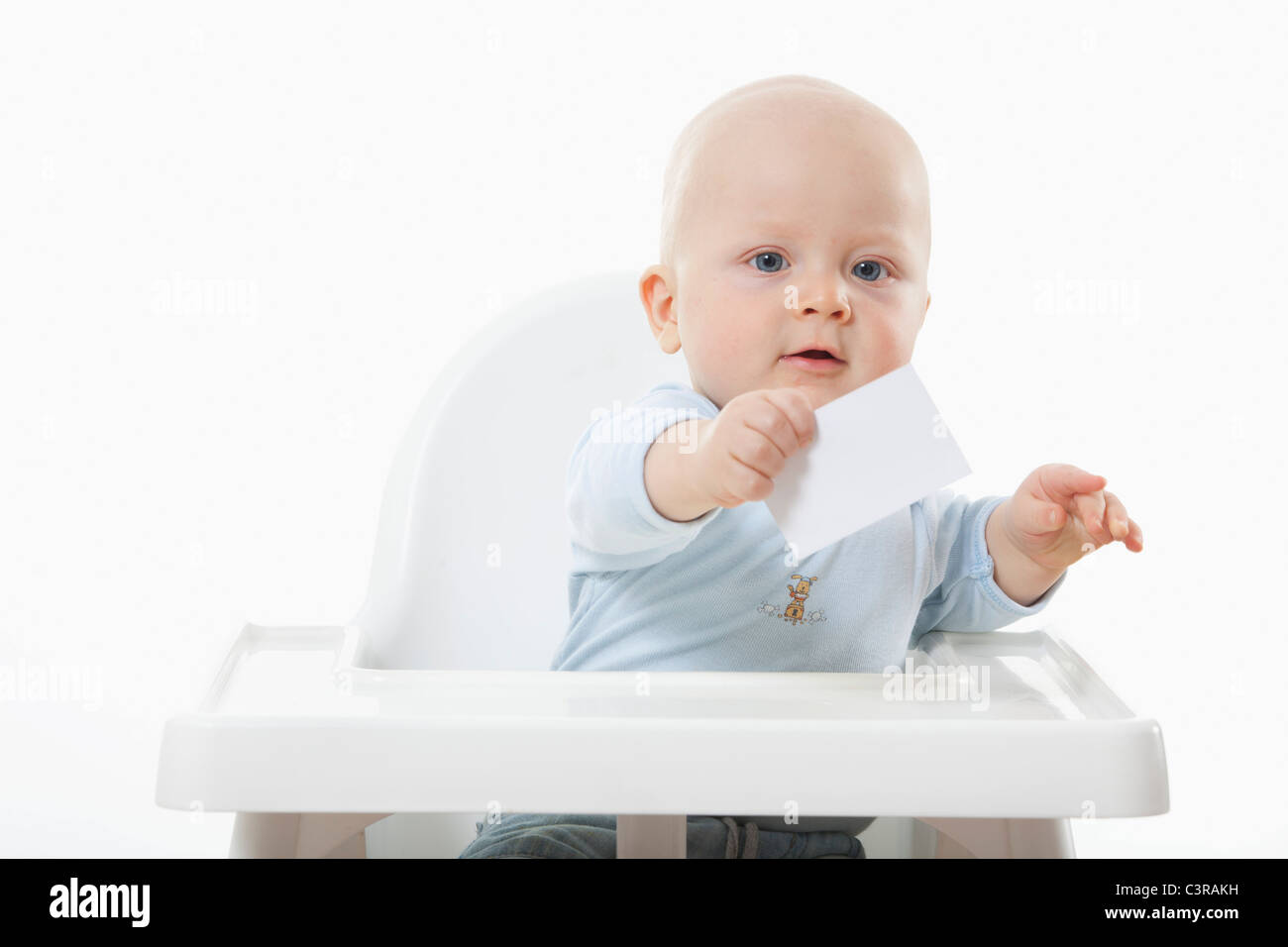 Baby Boy (6- 11 meses) que sujetan la tarjeta de presentación en blanco Foto de stock