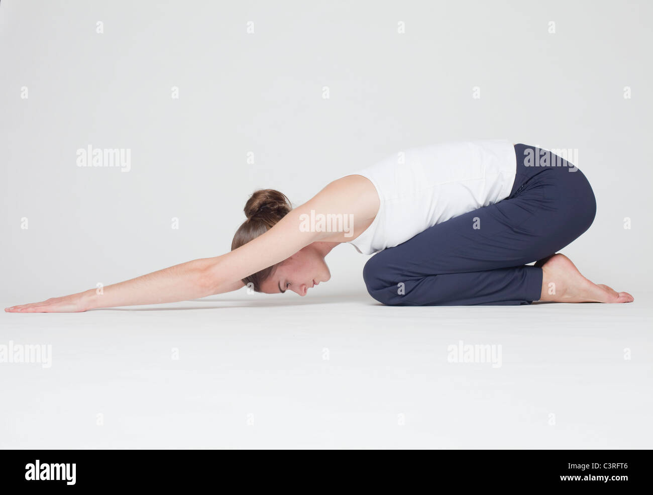 Estiramiento de la chica sobre fondo blanco. Foto de stock