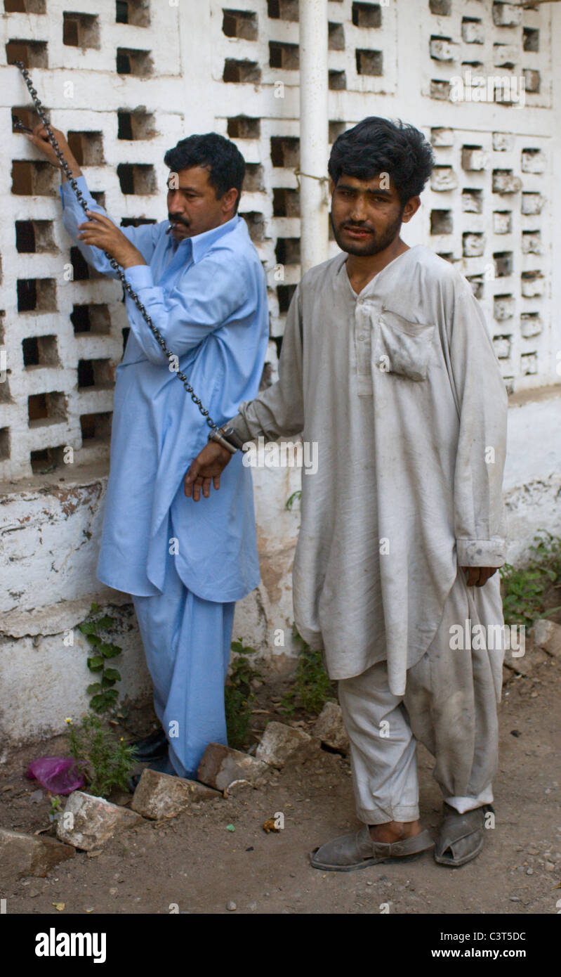 Un pick pocket capturados por la policía es encadenados en la comisaría cerca del Bazar de traficantes. Foto de stock