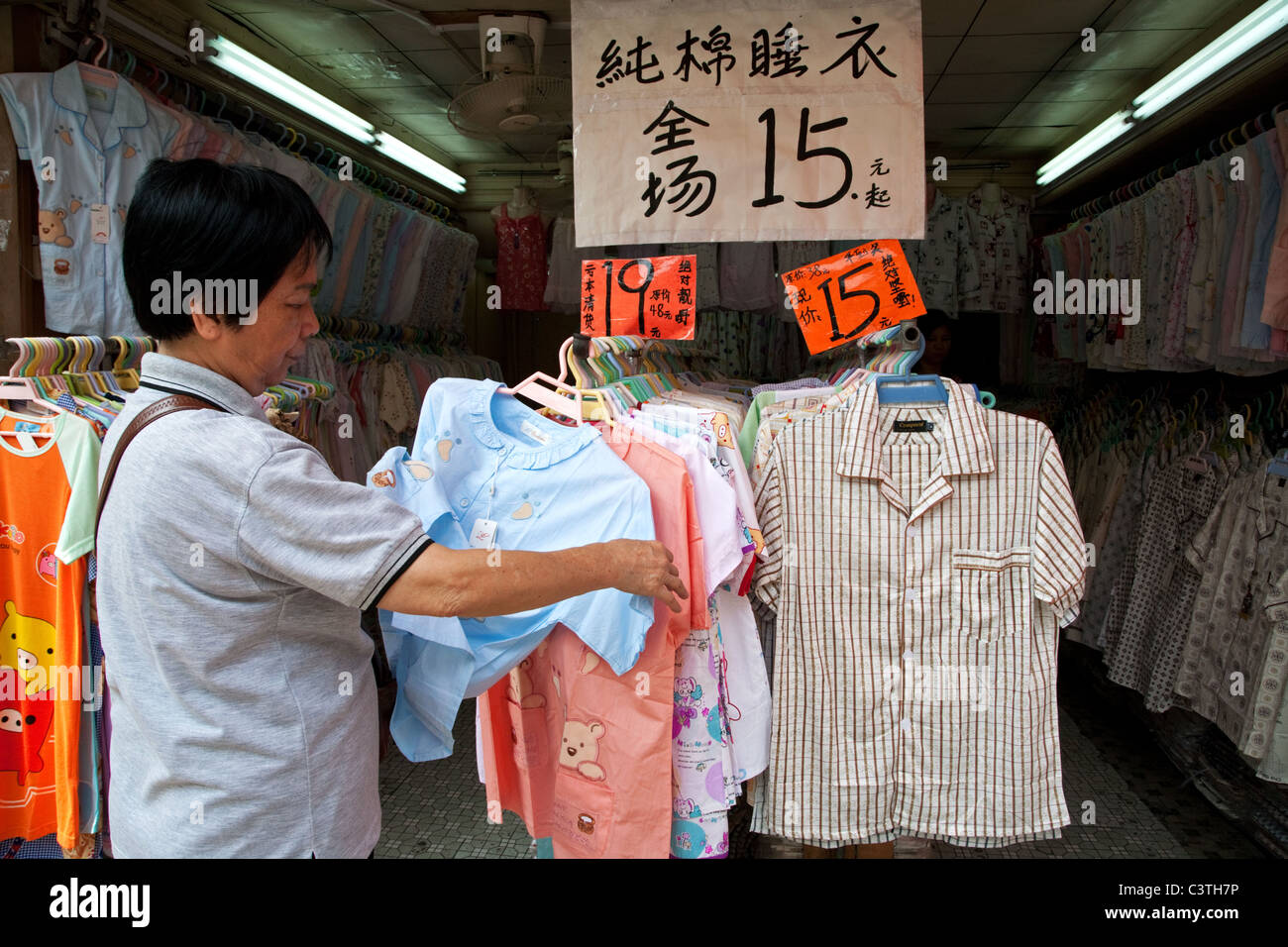 Mujer compras para la ropa en una tienda en Guangzhou, China. 2007 Foto de stock