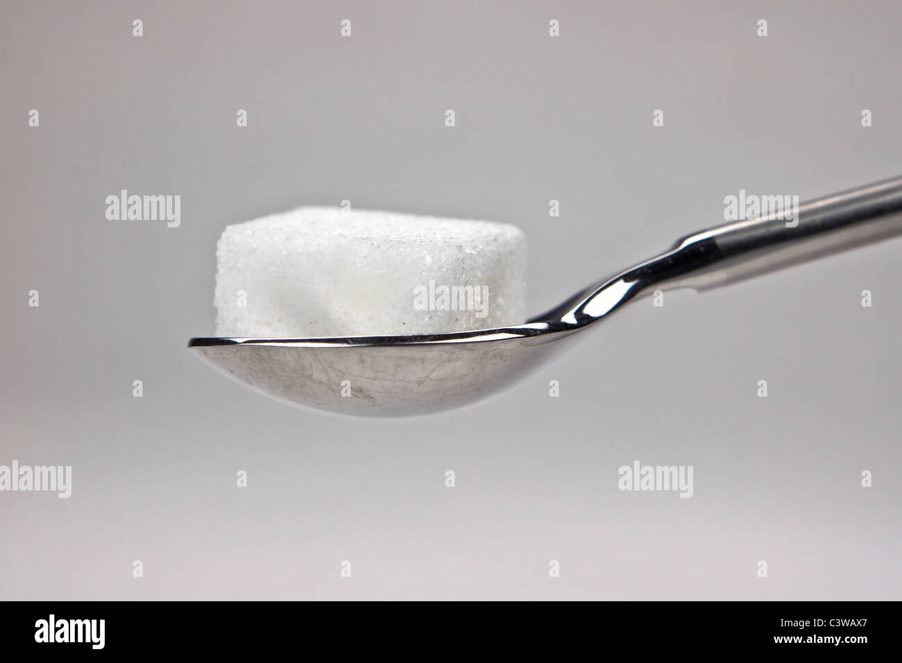 Pieza de terrones de azúcar en una cuchara Foto de stock