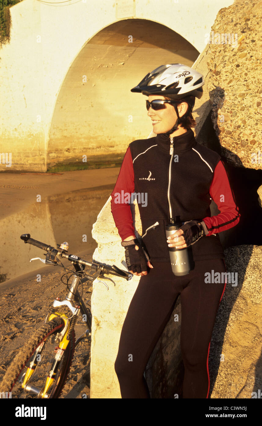 Mujer de pie junto a la bicicleta de montaña. Foto de stock