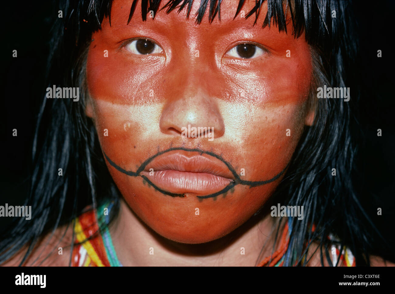 Pintura roja cubre la mitad superior de un indio Matses cara de mujer. Ella  también lleva un tatuaje de boca tradicional Fotografía de stock - Alamy