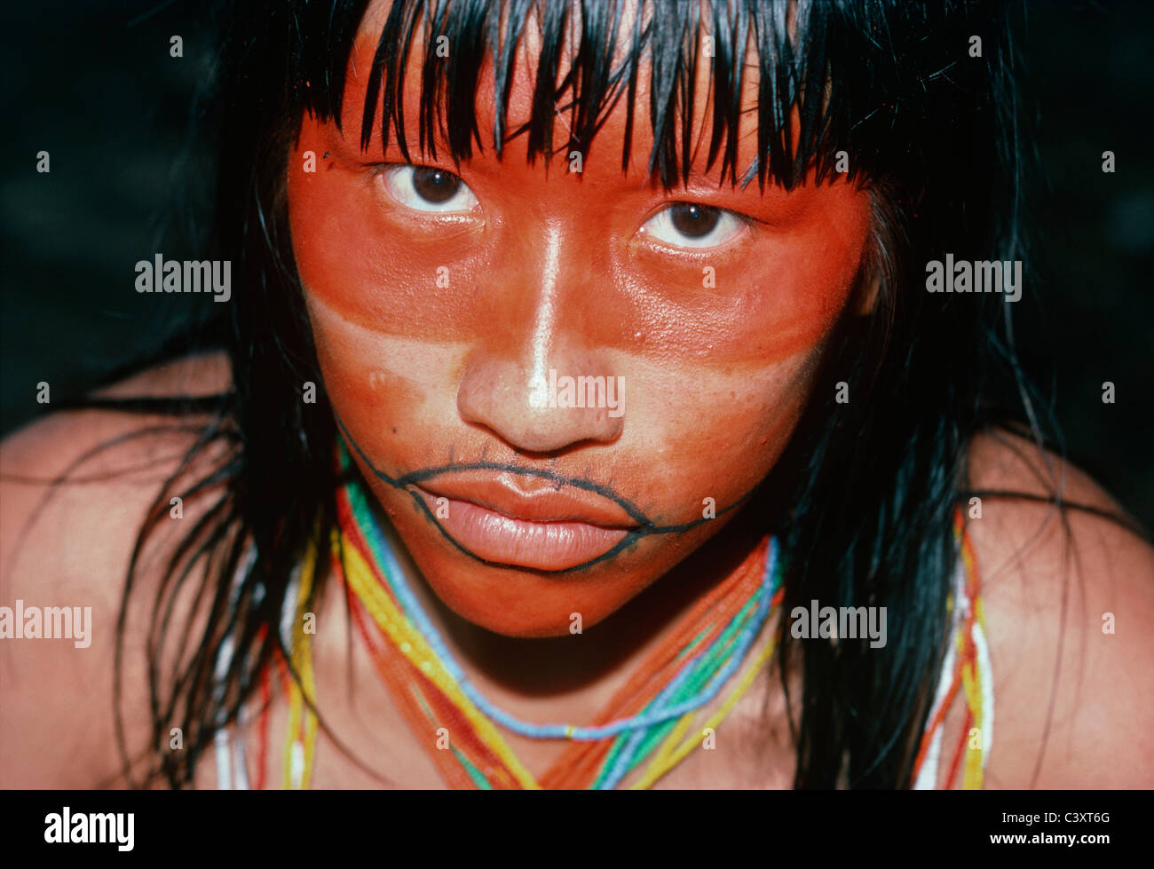 Pintura roja cubre la mitad superior de un indio Matses cara de mujer. Ella  también lleva un tatuaje de boca tradicional Fotografía de stock - Alamy