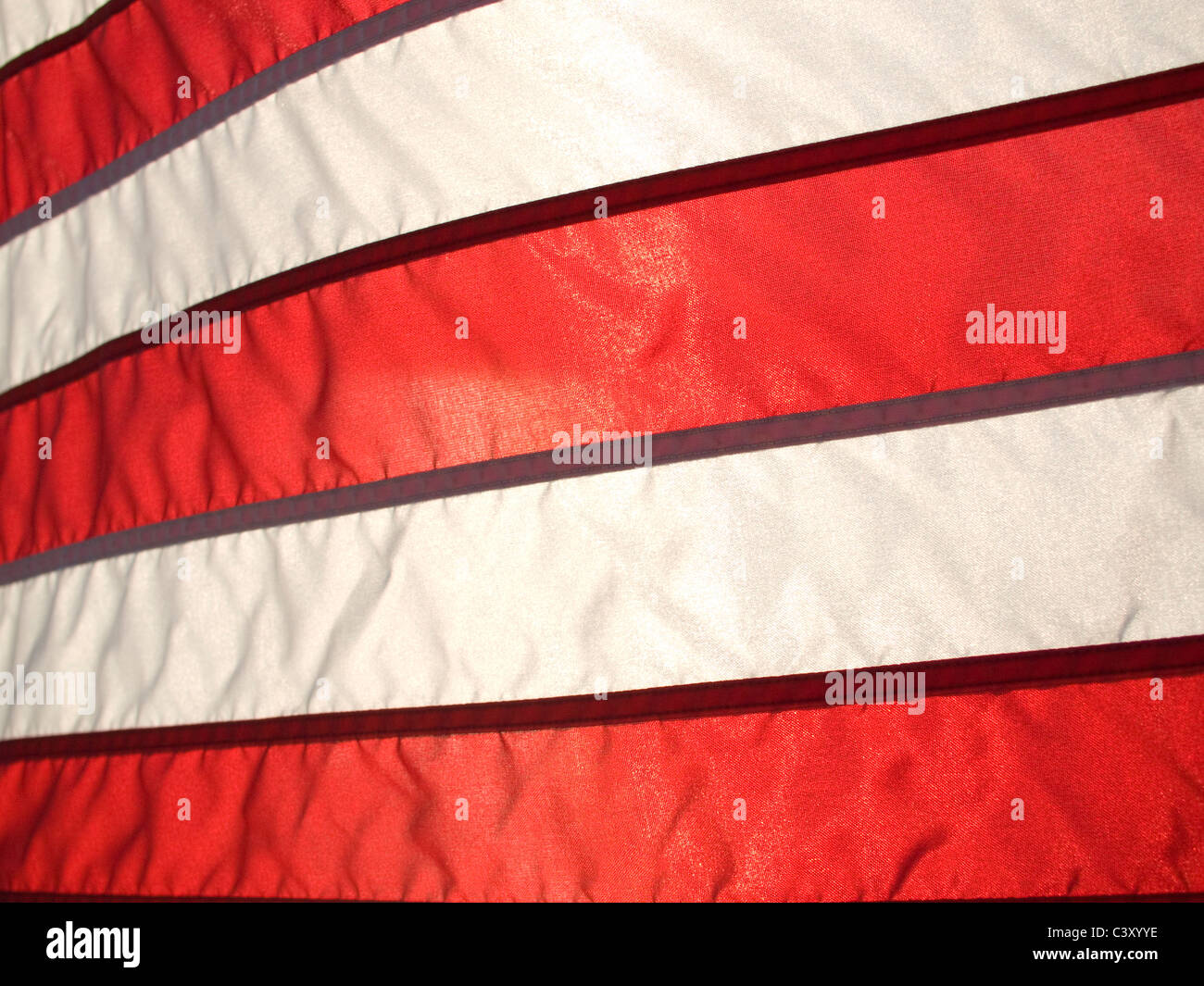 Bandera americana ondeando en el viento iluminada desde atrás por Sun. Foto de stock