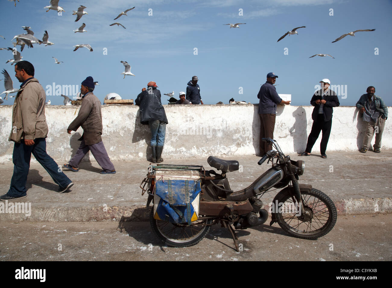 La gente trabaja en el mercado de pescado en la costa del Atlántico en Essaouira, Marruecos Foto de stock