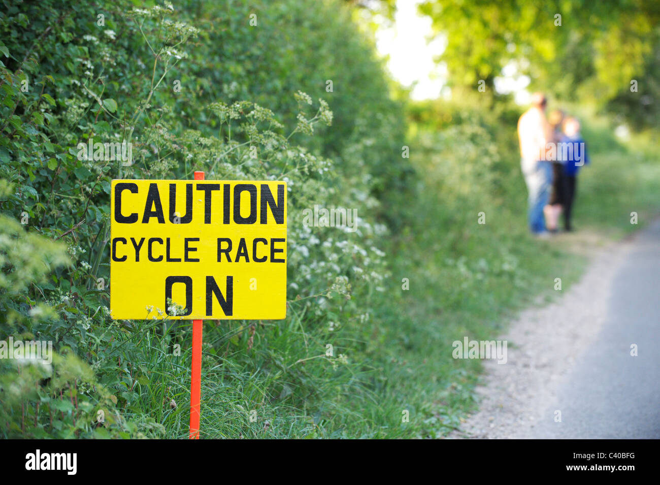 Carrera ciclista de precaución sobre el signo - en el carril del país británico para los aficionados a la carrera de ciclismo Foto de stock