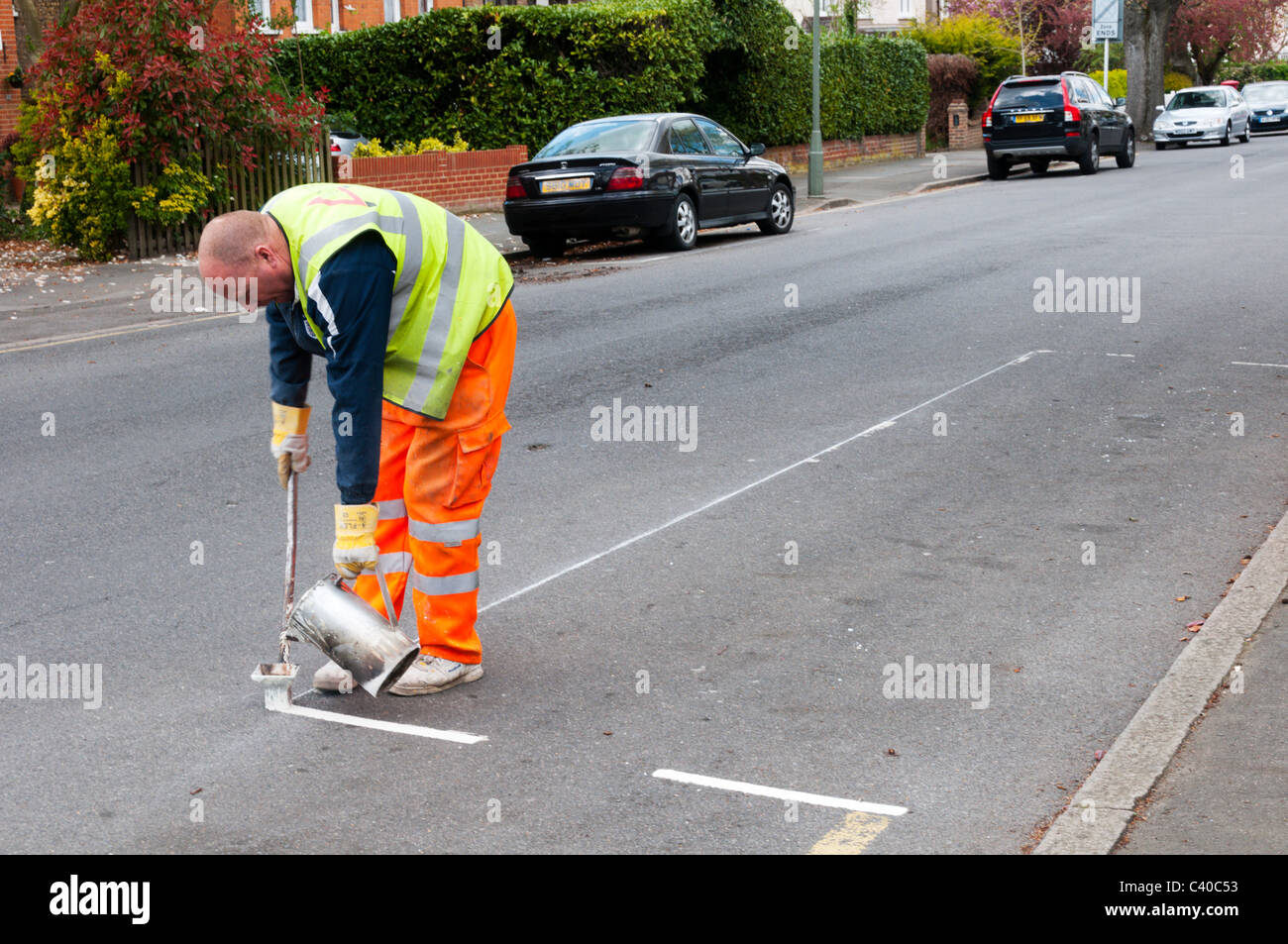 Los trabajadores de Alexander carreteras UK marcando las líneas amarillas y los estacionamientos. Foto de stock