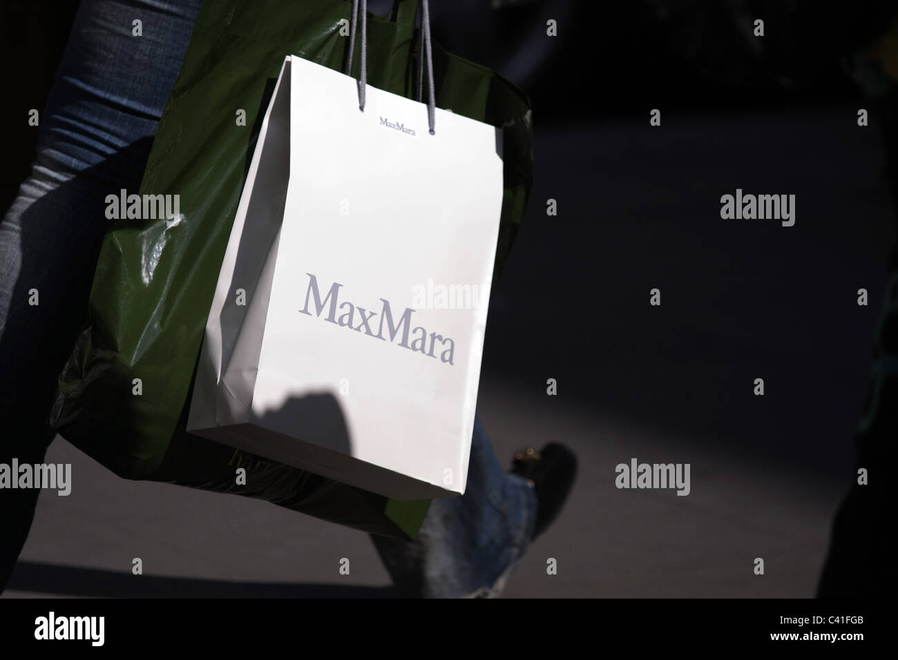 Las piernas de una persona caminando y llevar un bolso de compras Max Mara  en Londres Fotografía de stock - Alamy