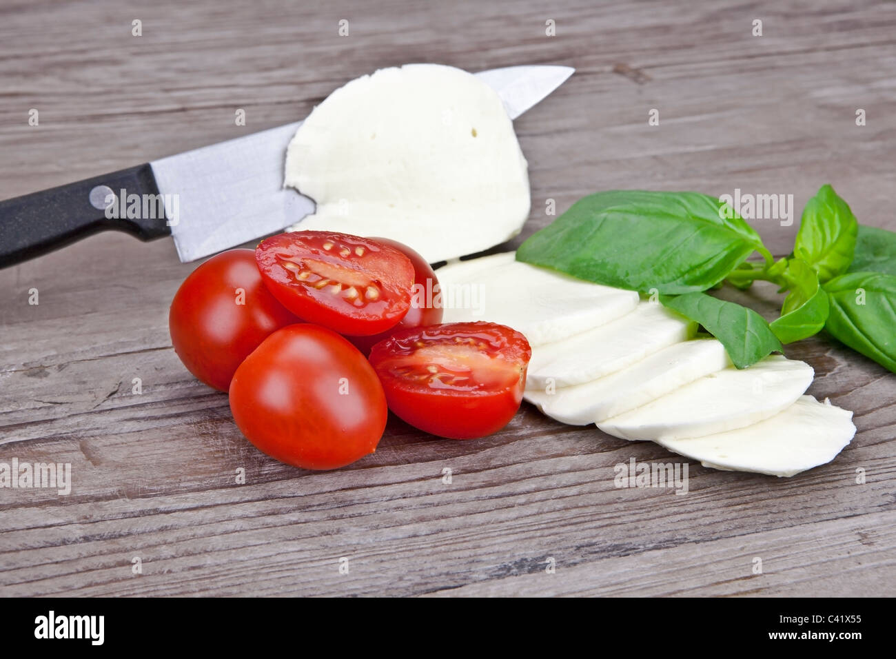??En rodajas de mozzarella con rodajas de tomate y albahaca ? Foto de stock