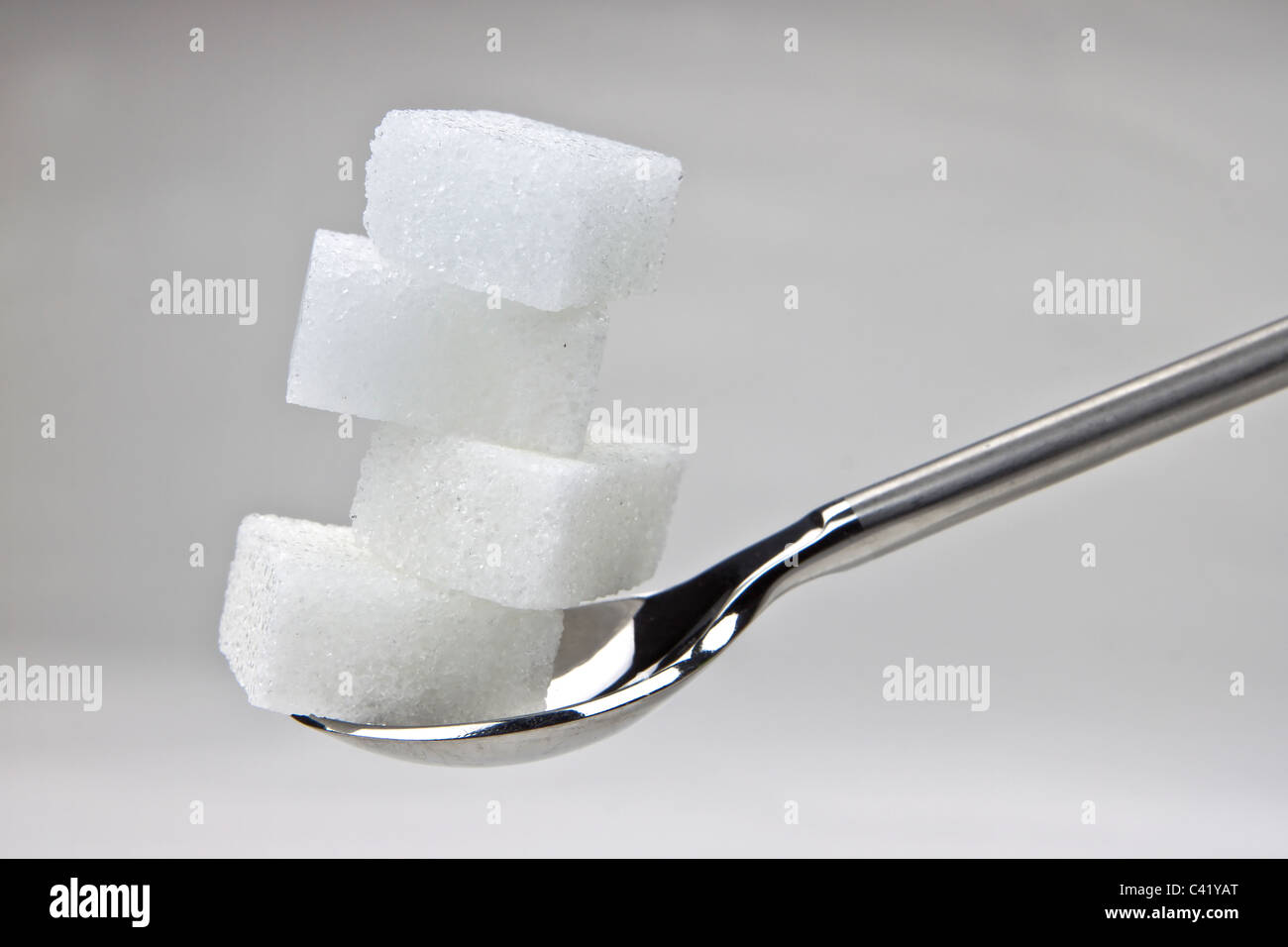 Pieza de terrones de azúcar en una cuchara Foto de stock