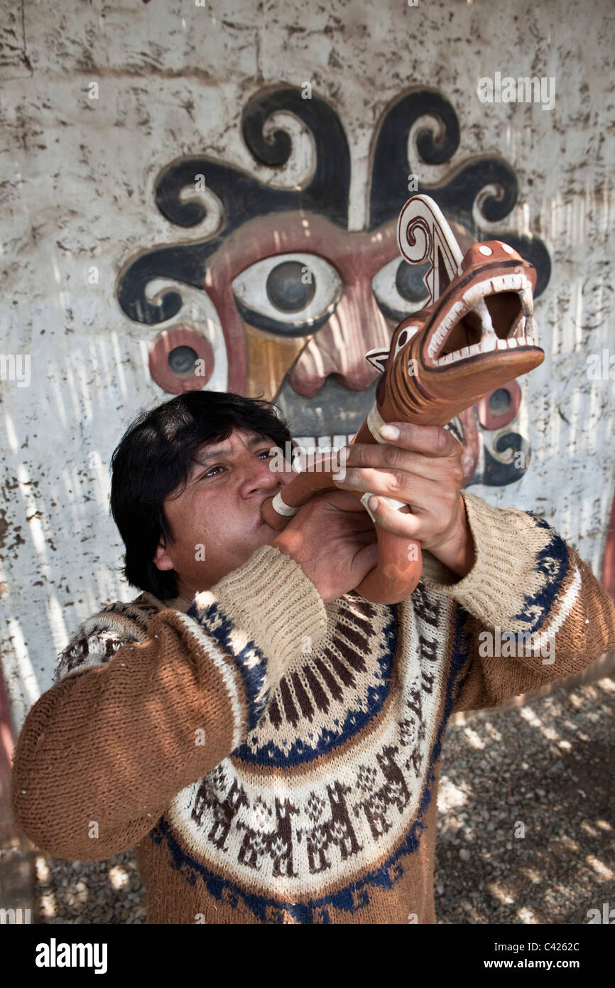 Perú, Trujillo, hombre de origen indio que sopla sobre la bocina (réplica) de la cultura Moche, aproximadamente entre 200 y 850 AD. Foto de stock