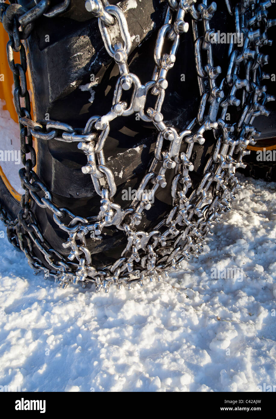 Nuevas cadenas de nieve de punta brillante adheridas a un neumático para cosechadoras forestales, Finlandia Foto de stock