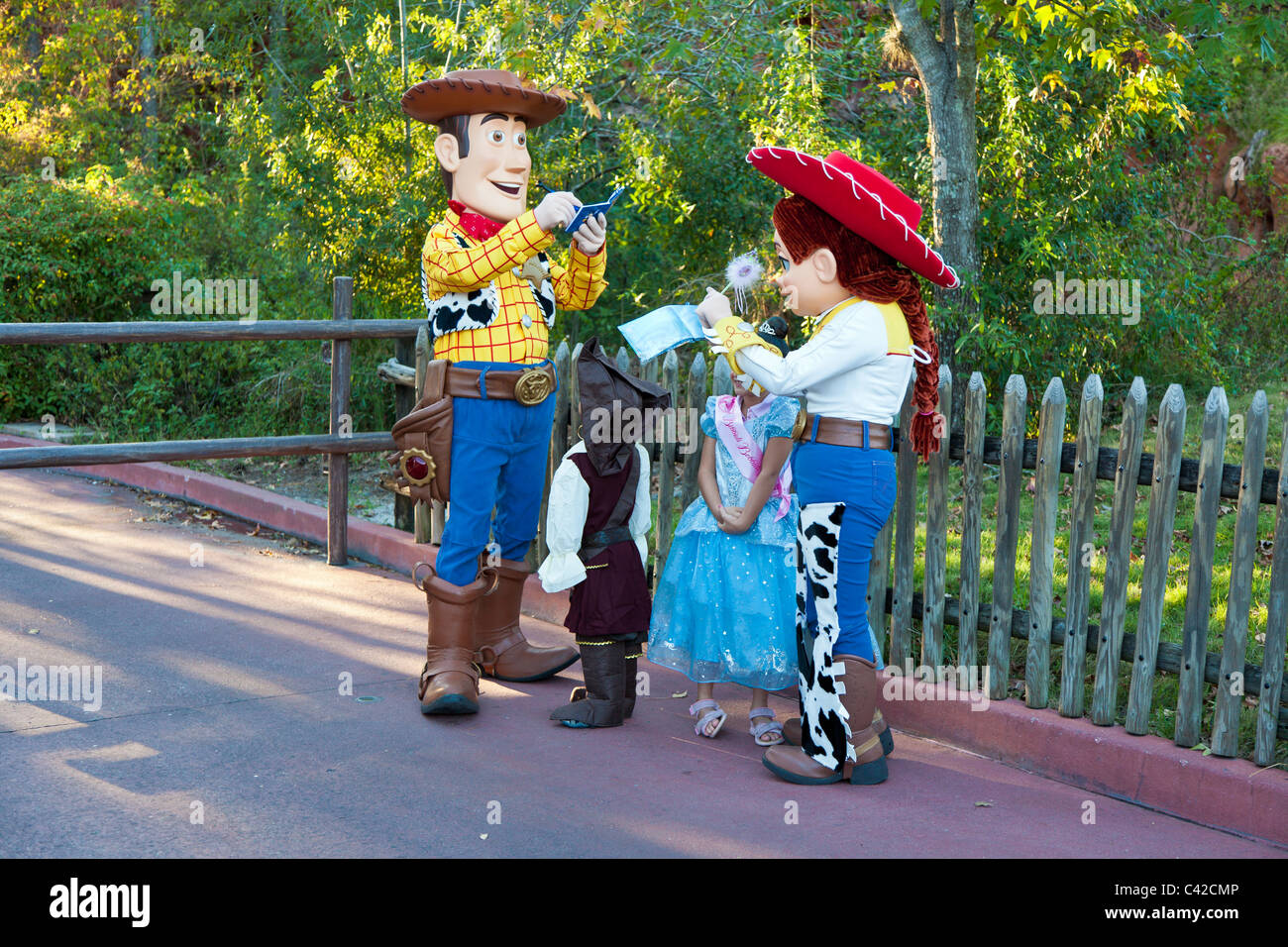 Personajes de Toy Story Woody y Jessie firmar autógrafos para los niños pequeños en el Reino Mágico de Disney World, Kissimmee, Florida Foto de stock