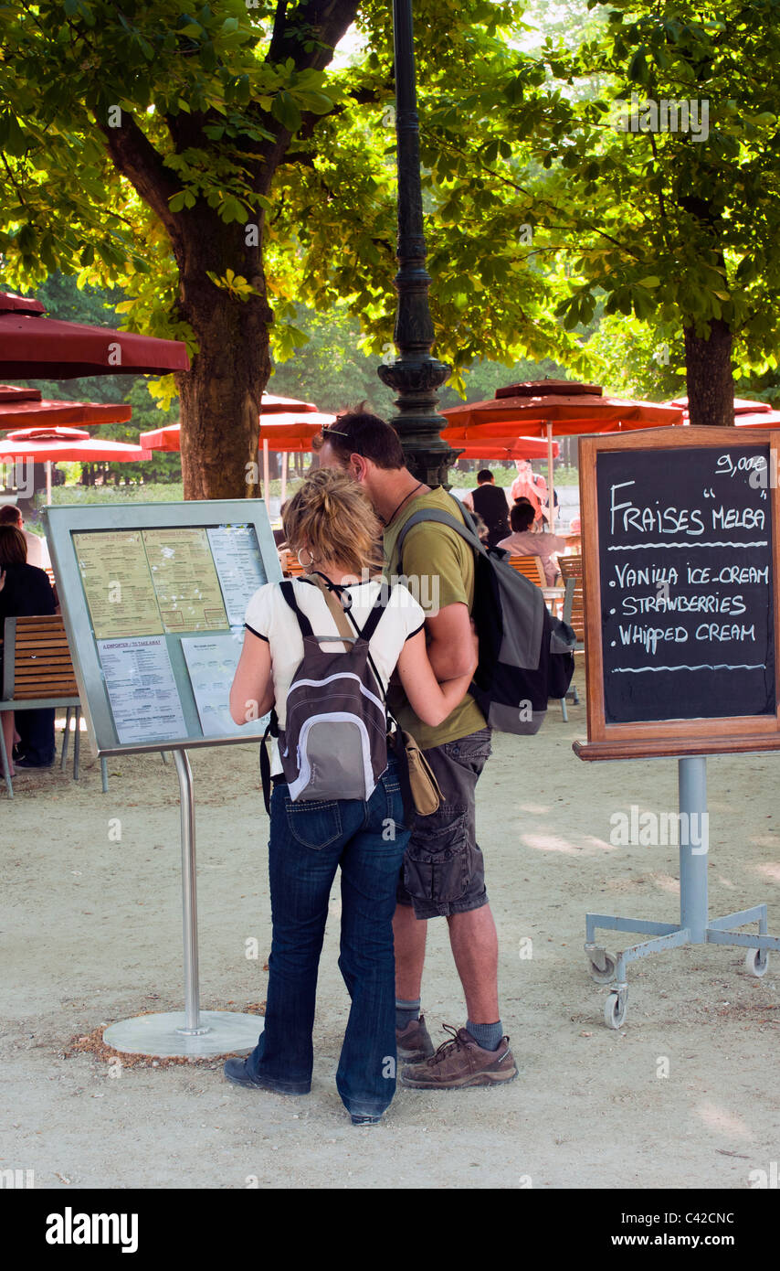 Pareja mirando el menú junta en Café al aire libre en el Jardin du Tuilleries Foto de stock
