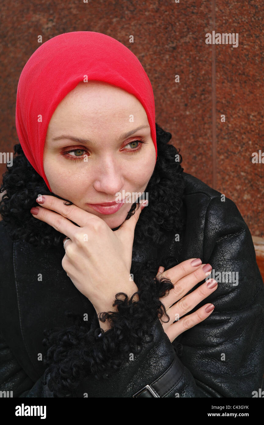 La triste chica en un pañuelo rojo y un abrigo negro se sienta en un banco,  Moscú, Rusia Fotografía de stock - Alamy