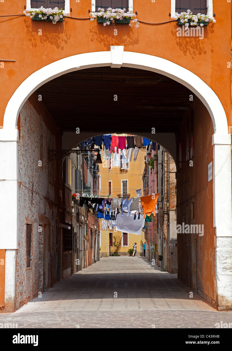 Venecia Arco de entrada con lavado colgando sobre la calle adoquinada Italia Europa Foto de stock