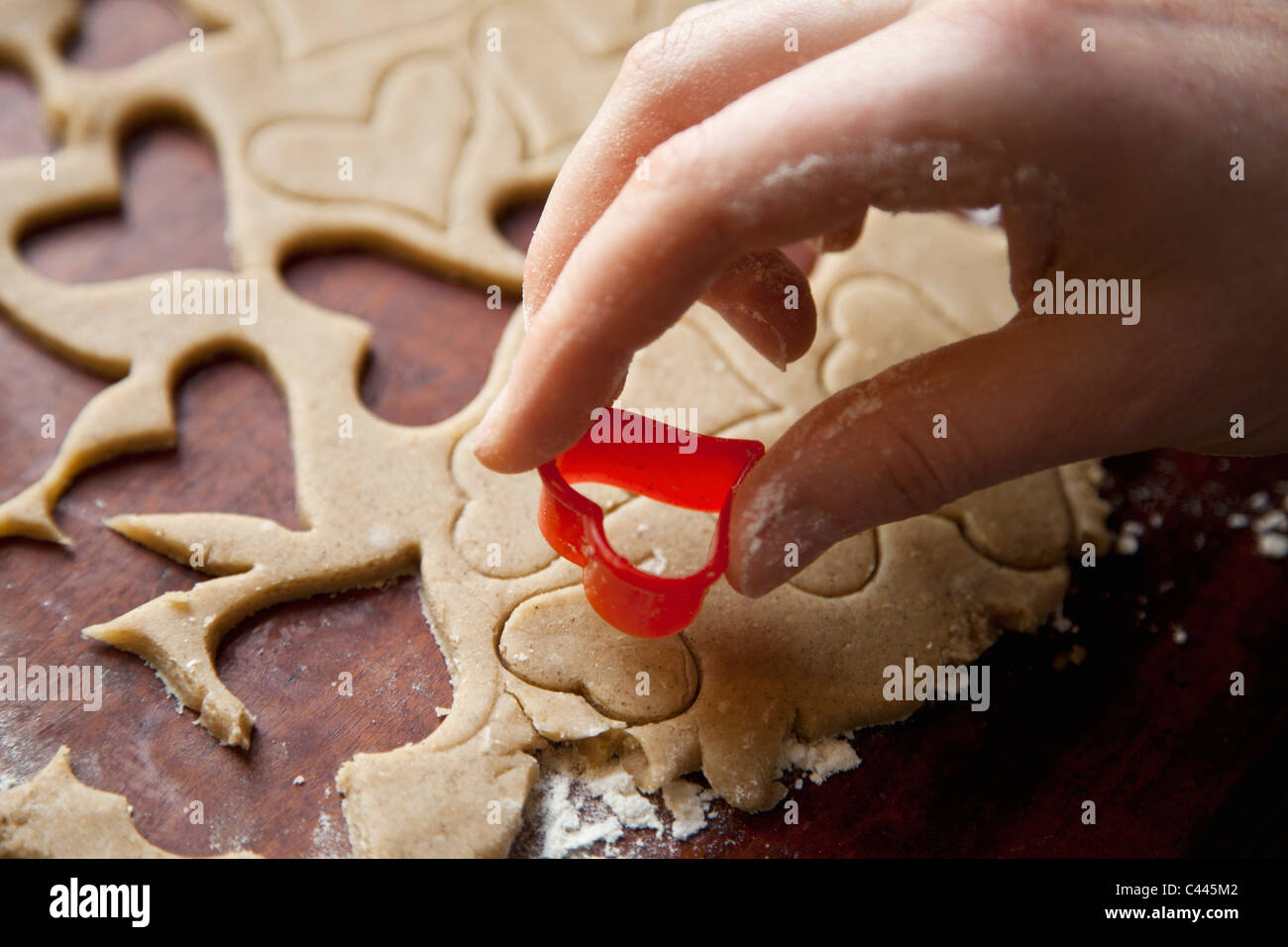 Detalle de una mano con una forma corazón cookie cutter Foto de stock