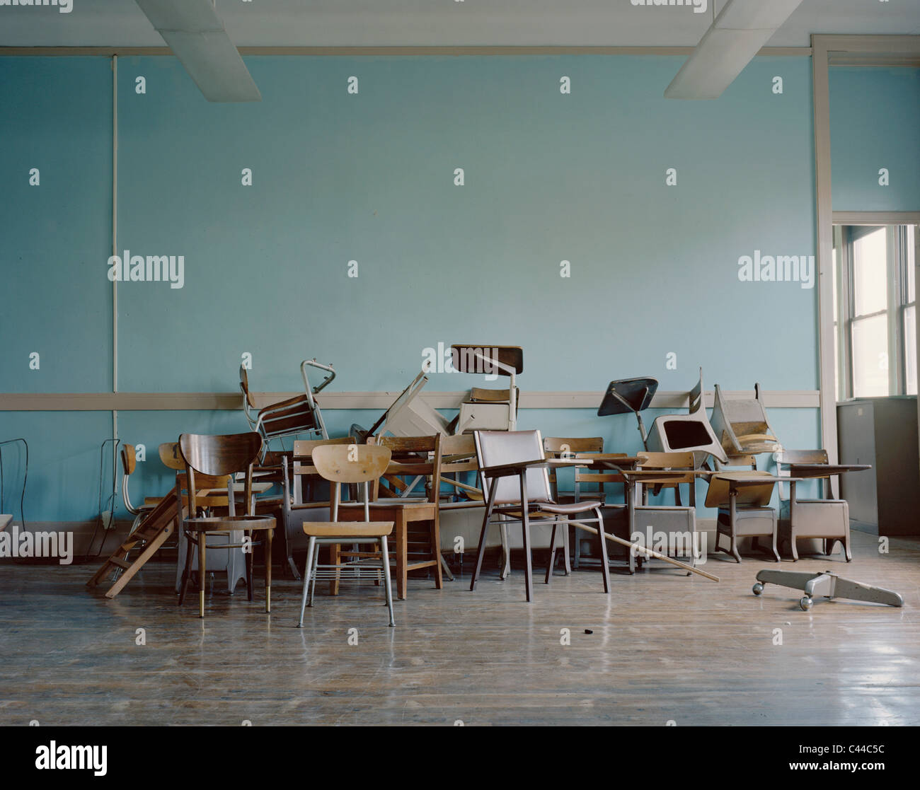 Viejos, las sillas rotas en una escuela abandonada Foto de stock