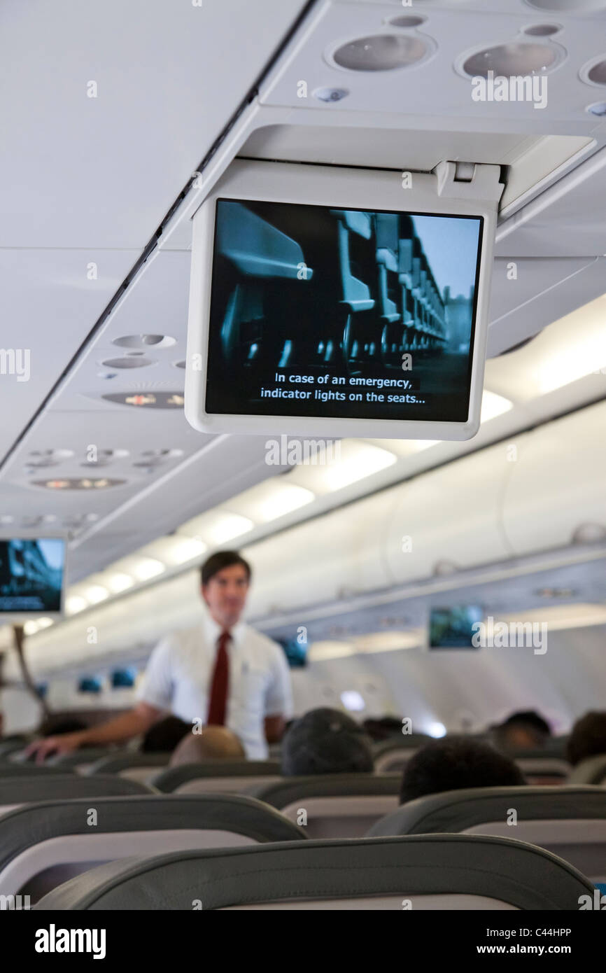 Instrucciones de seguridad sobre monitores antes de despegar dentro de un avión. Aerolínea TACA Foto de stock