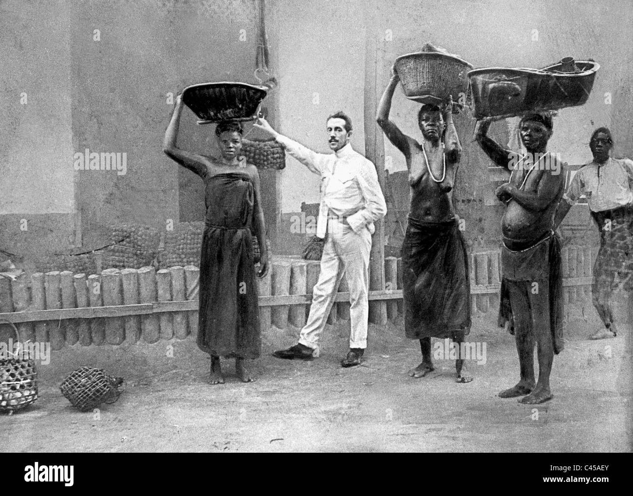 Empleado belga supervisa las trabajadoras negras en una plantación, 1899 Foto de stock