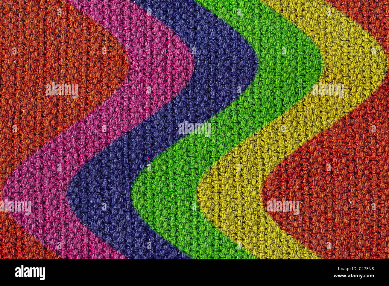 Una textura de fondo una textura de lana tejida con tiras de color curvas. Foto de stock