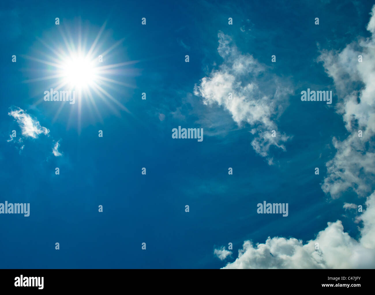 Sun starburst de cielo azul y nubes blancas Foto de stock