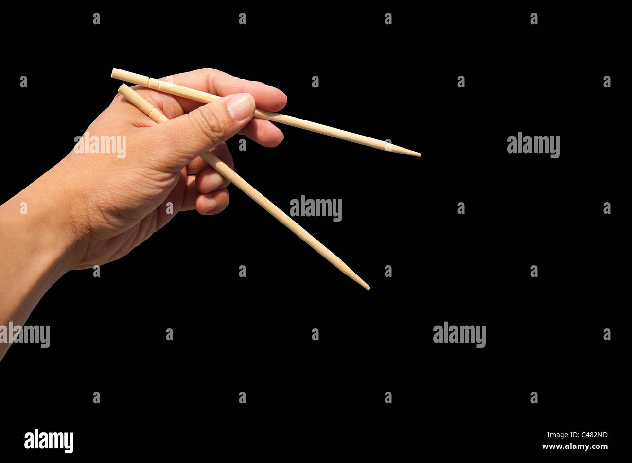 Mano y palillos de bambú Foto de stock
