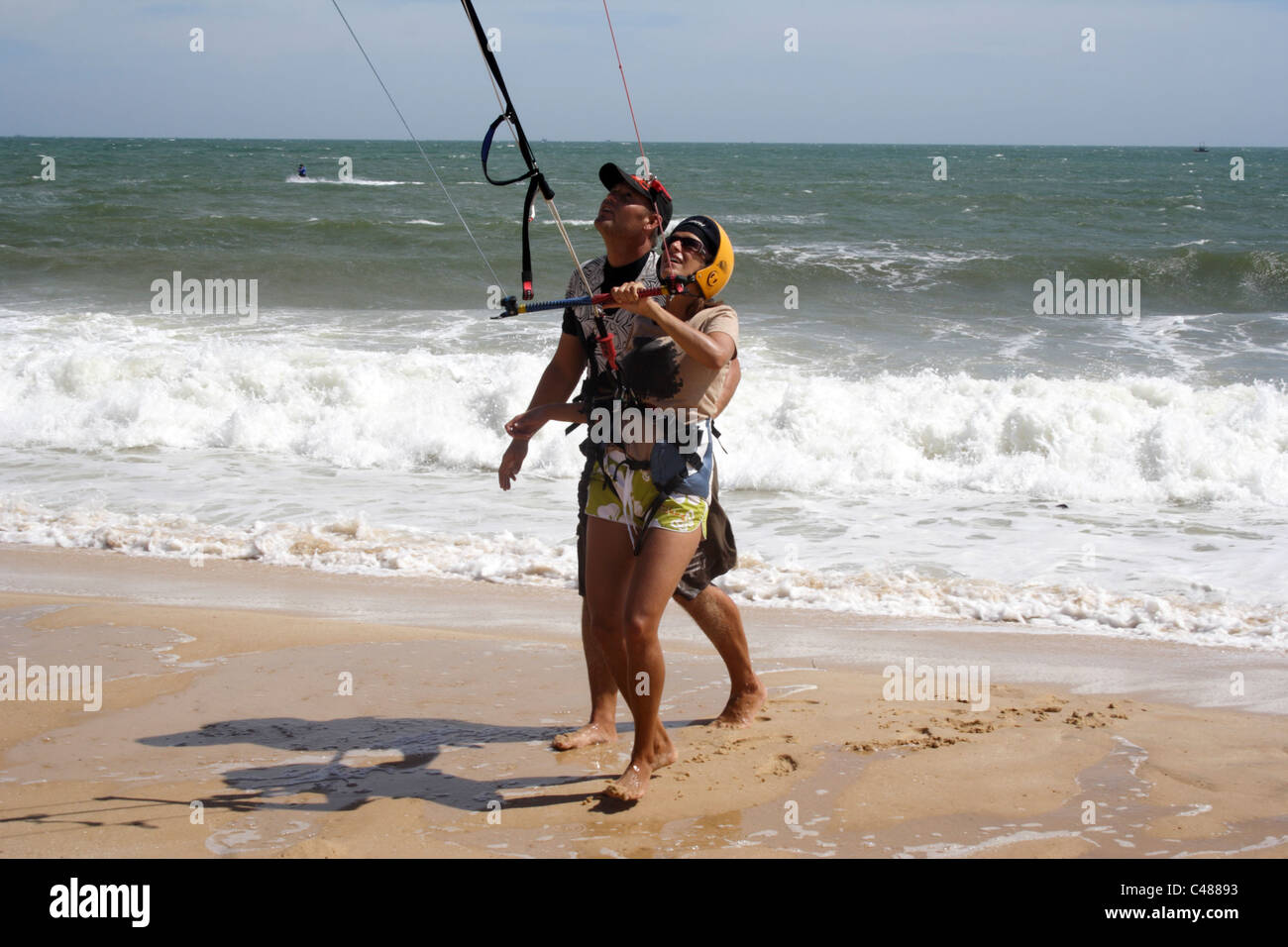 Mujer chica que kite surf lección en muine playa en Vietnam. shorts casco  ola mirando al sol viento kite deporte divertido Fotografía de stock - Alamy