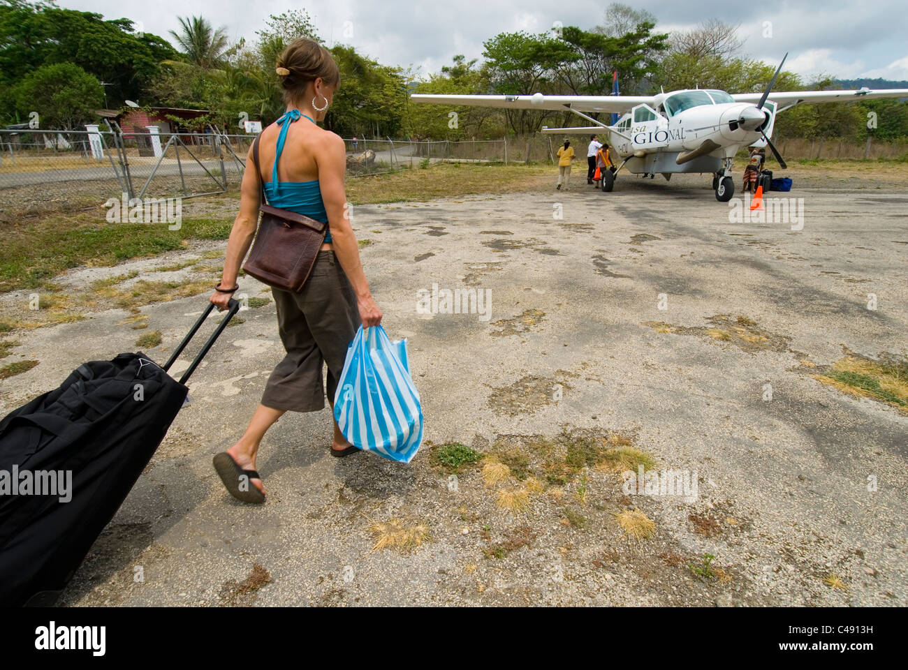 Una mujer tablas un pequeño avión con su equipaje en un aeropuerto en Costa  Rica Fotografía de stock - Alamy