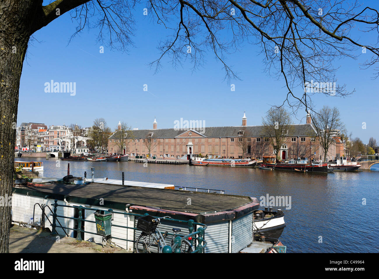 Casa flotante en el río Amstel, en frente del Museo del Hermitage y Magere Brug, Amsterdam, Países Bajos Foto de stock