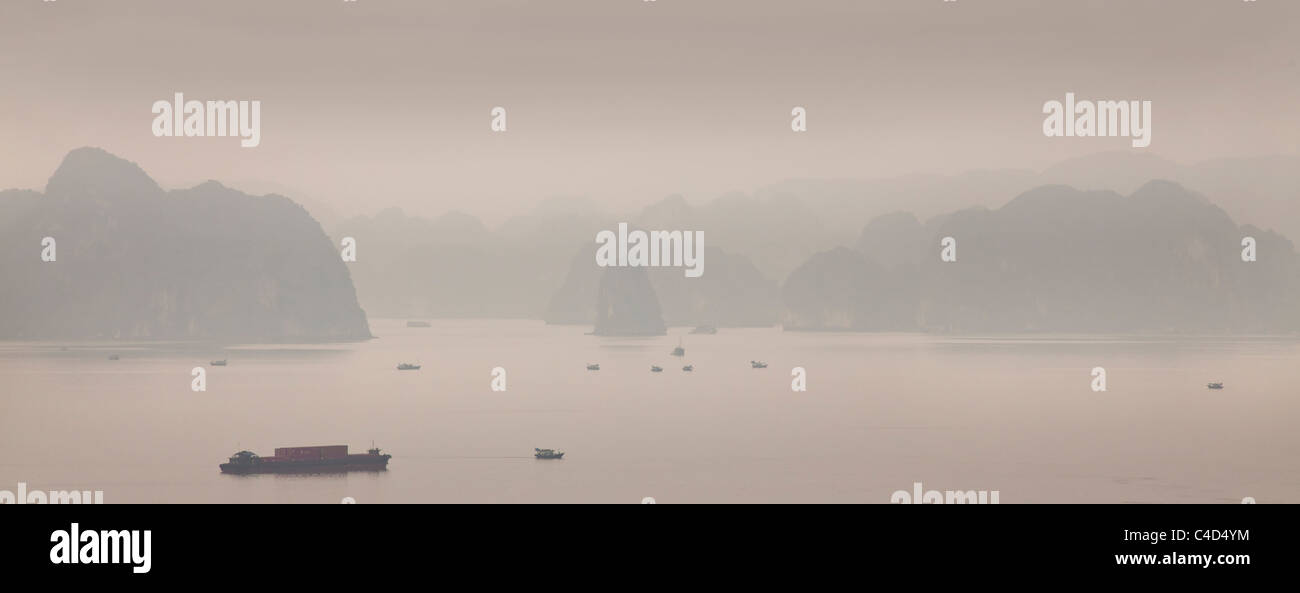 La bahía de Halong, Vietnam, envuelve la niebla de la mañana temprana de islotes de piedra caliza Foto de stock