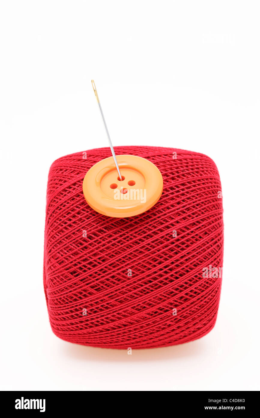 La aguja y el hilo de coser en un blanco Foto de stock