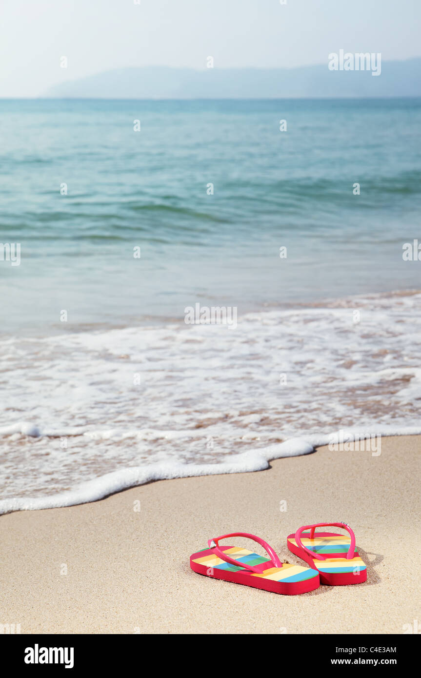 Concepto de vacaciones de verano--Flipflops en una arenosa playa. Foto de stock