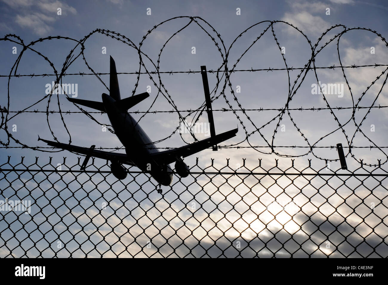 Un avión de aterrizaje cruzar la alambrada de cerco perimetral en el aeropuerto de Heathrow Foto de stock