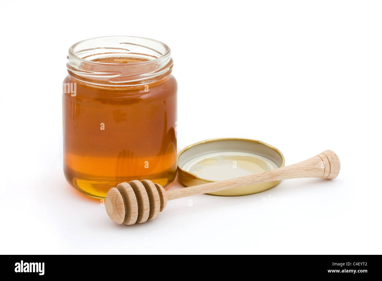 Tarro de miel con drizzler abierto sobre blanco Foto de stock