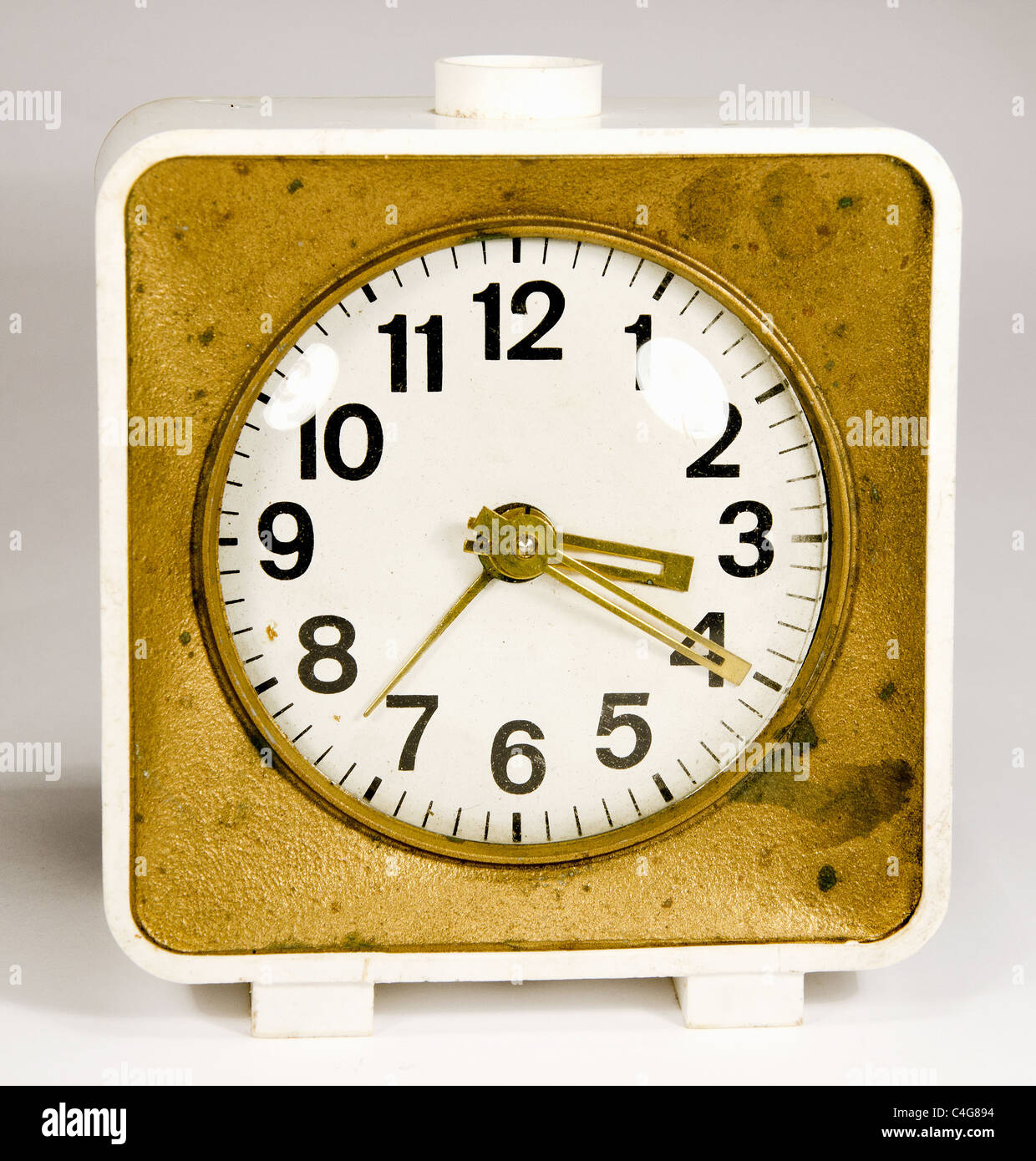 Antiguo reloj con tres flechas que muestran 3:20. Oro blanco antiguo reloj alarma. Foto de stock