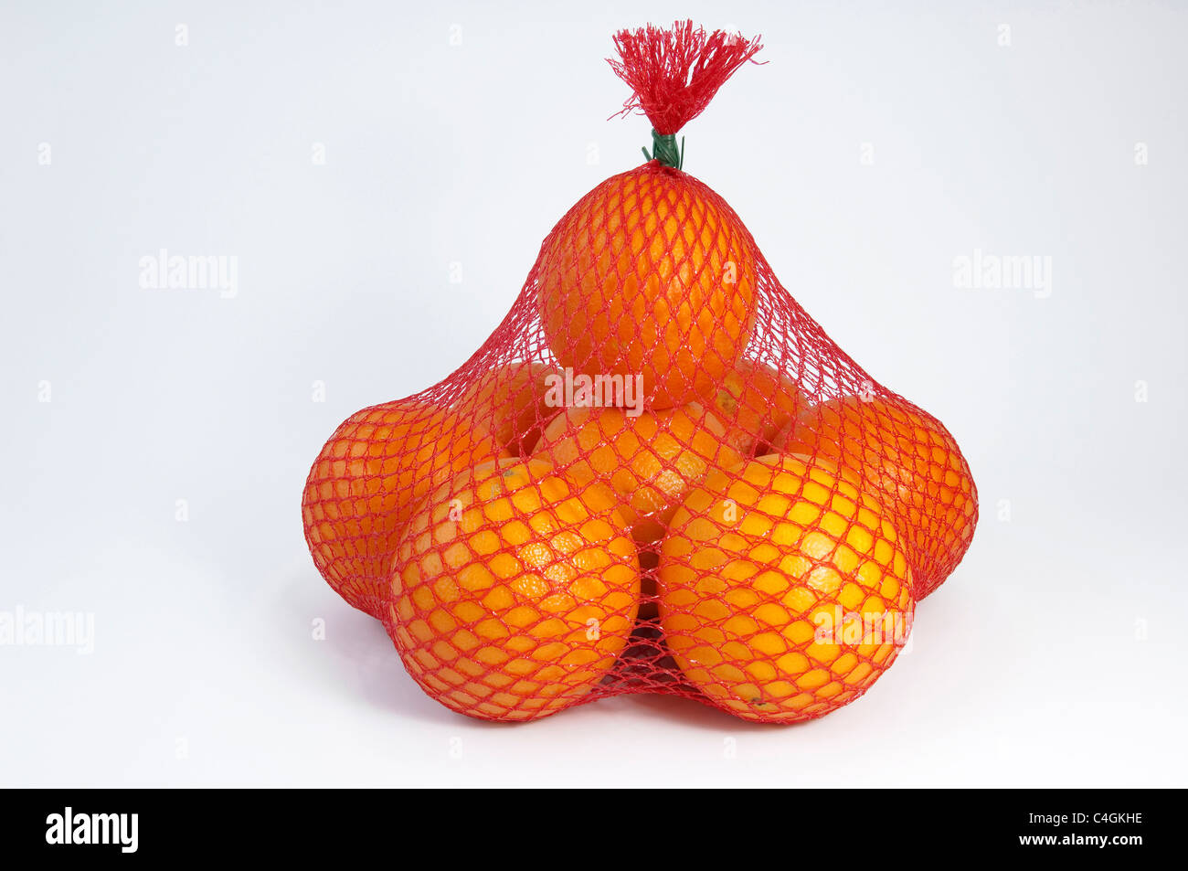 Naranja (Citrus sinensis), fruta en una red. Studio picture contra un fondo blanco. Foto de stock