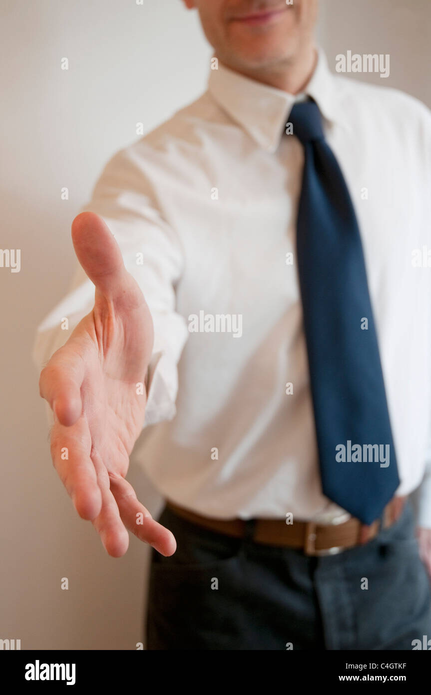 El hombre extiende su mano abierta, ofreciendo apretón de manos. Foto de stock