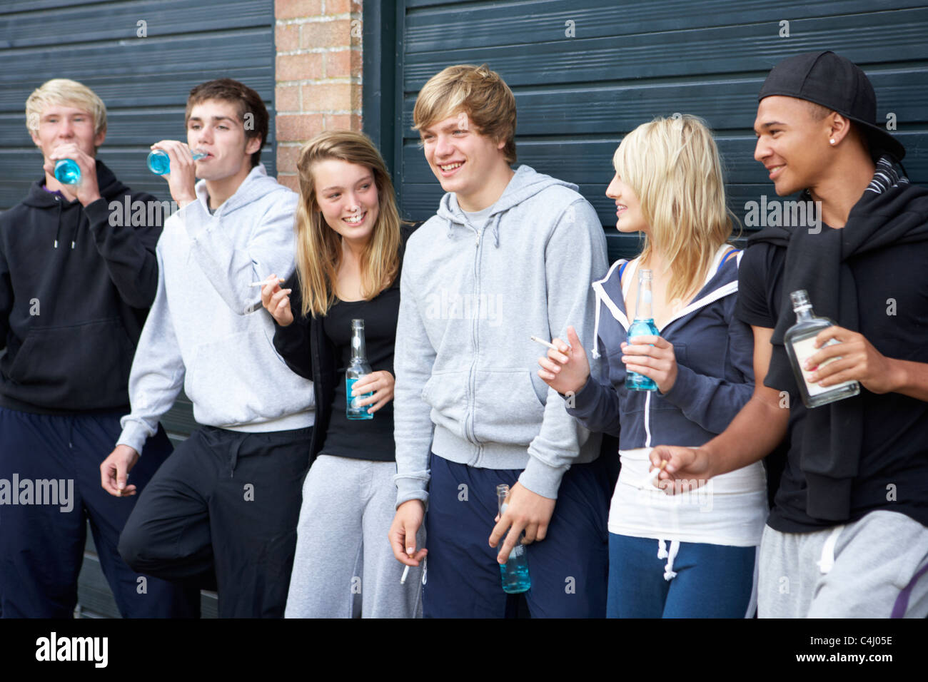 Grupo de Adolescentes colgando fuera bebiendo juntos Foto de stock