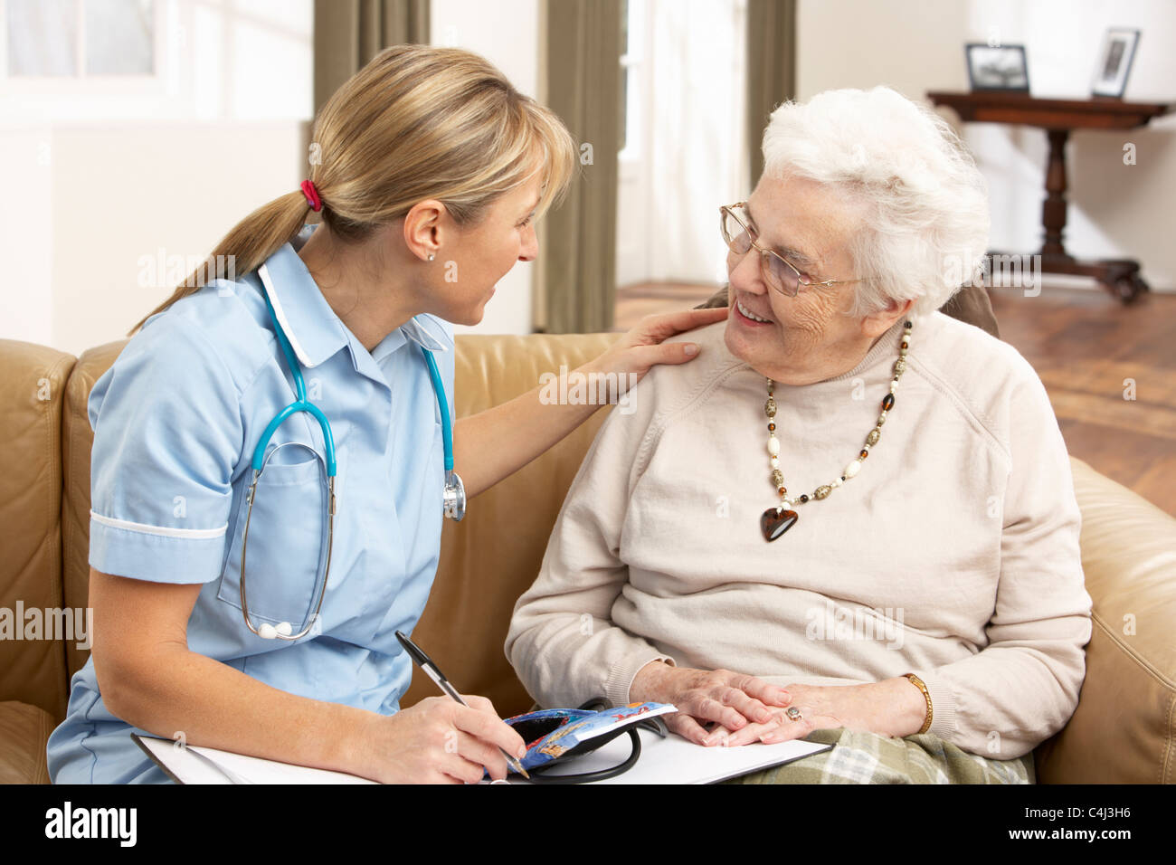 Mujer senior en la discusión con el visitador de salud en el hogar Foto de stock