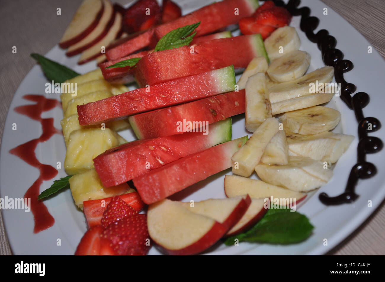 Plato de frutas mezclados con salsa de chocolate Foto de stock