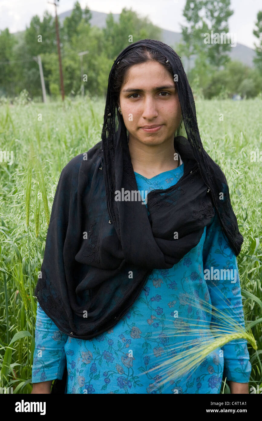 La mujer está en Cachemira en campos de pasto Manasbal cerca del lago, en el estado de Jammu & Kashmir, India Foto de stock