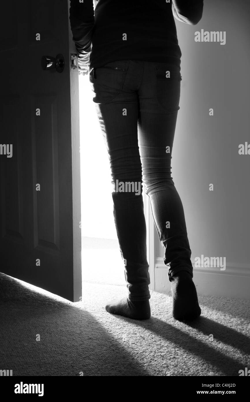Vista posterior de una joven salir de la habitación Foto de stock