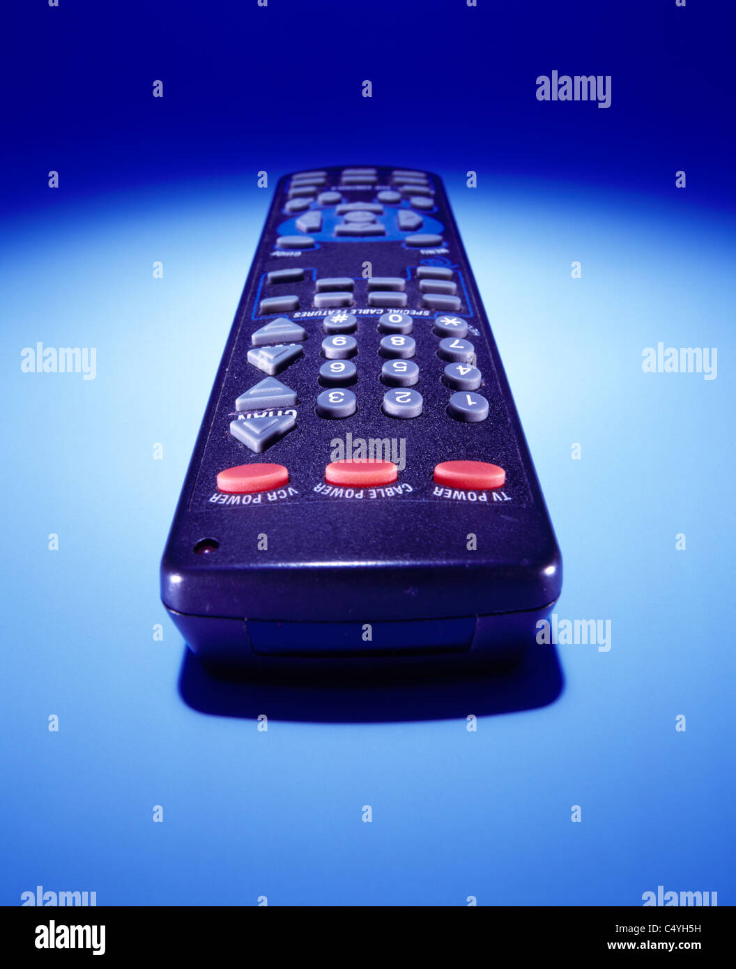 Un DVD de vídeo del televisor o dispositivo de control remoto por cable sobre un fondo azul brillante Foto de stock